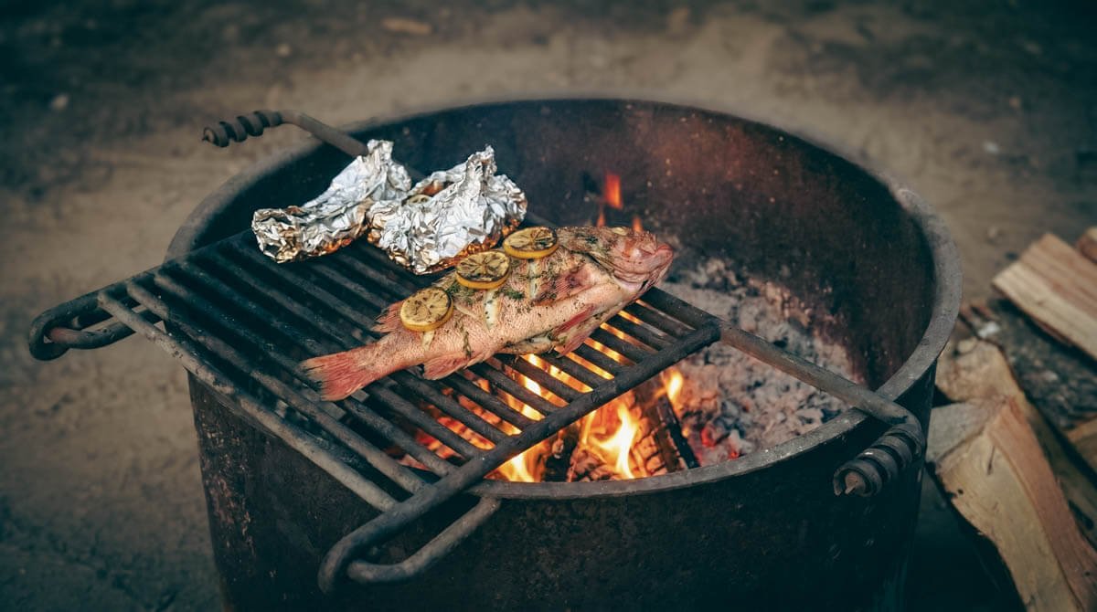 Whole Pacific Rockfish grilling over a wood fire